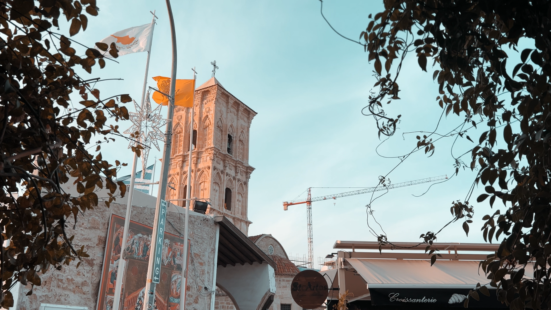 Church of Saint Lazarus tower in Larnaca with Cyprus flags and the StoArtos sign below